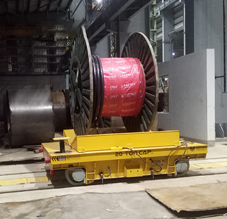 electric flat rail cars transporting heavy cable reel in workshop